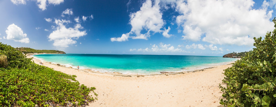 Panorama picture of white sandy beach and turquoise waters on carrebian island of St. Maarten