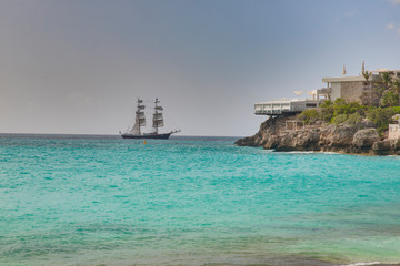 Obraz premium Sailing ship in turquoise waters on carrebbian island of St. Maarten