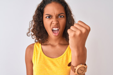 Young brazilian woman wearing t-shirt standing over isolated white background annoyed and frustrated shouting with anger, crazy and yelling with raised hand, anger concept