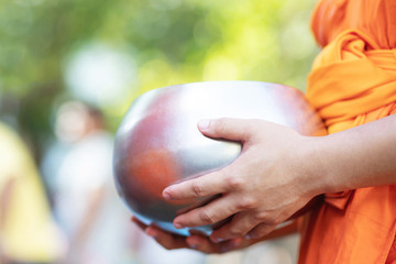 monk with hand holding give alms bowl which came out of the offerings in the morning at Buddhist temple, Culture Heritage Site tradition and Religion Buddhism ,South east asia.