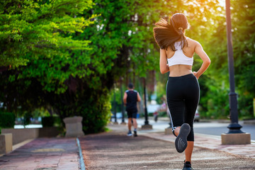 Beautiful woman jogger outdoor living healthy lifestyle in city park. Concept sport and a healthy...