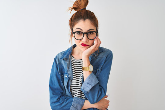 Redhead woman wearing striped t-shirt denim shirt and glasses over isolated white background thinking looking tired and bored with depression problems with crossed arms.