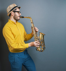 Fototapeta na wymiar saxophone players on grey background. Saxophonist jazz man with Sax. Music concept