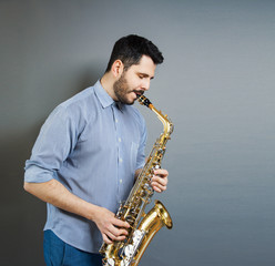 Fototapeta na wymiar saxophone players on grey background. Saxophonist jazz man with Sax. Music concept