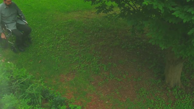 man in wheelchair moving through grass
