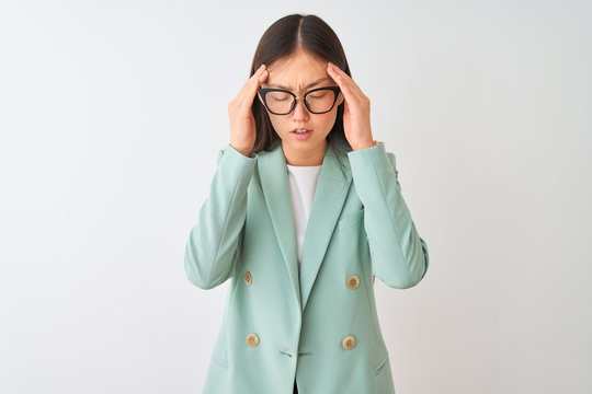 Chinese businesswoman wearing elegant jacket and glasses over isolated white background with hand on head for pain in head because stress. Suffering migraine.