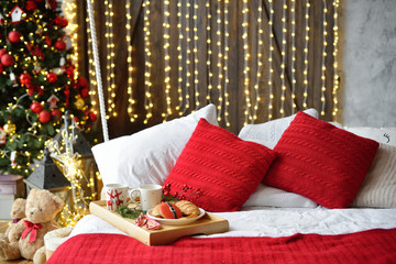 breakfast in bed, tray with cup of coffee and croissant. Modern bedroom interior. Romantic morning surprise.