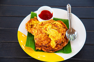 Egg omelet with ketchup on wood table