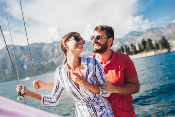 Loving couple spending happy time on a yacht at sea. Luxury vacation on a seaboat.