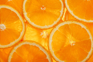 Slices of pulp and zest ripe orange with backlighting as a textural background, the substrate. Full screen, Close-up