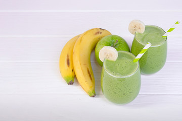 Banana mix apple smoothie green juice beverage healthy the taste yummy in glass for on white wood background.