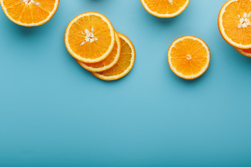 Slices and slices of orange pulp on a bright blue background as a textural background, the substrate. Full screen Flat lay, top view. Food background
