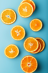 Slices and slices of orange pulp on a bright blue background as a textural background, the substrate. Full screen Flat lay, top view. Food background