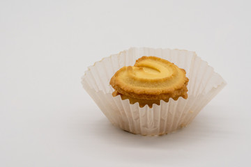 Stack of homemade cookie in white paper packaging on white