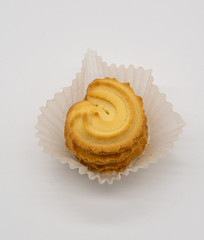 Stack of homemade cookie in white paper packaging on white