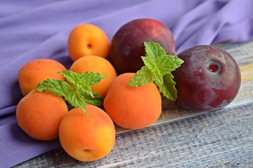 Ripe,sweet apricots and plums on wooden background.