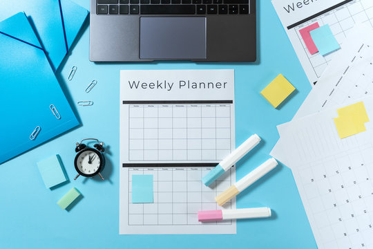 Laptop, stationery and planner on blue pastel background