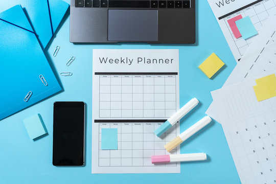 Smartphone, laptop, stationery and planner on blue pastel background