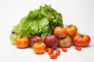 Lechuga verde y distintas frutas, tomates, cherri y de los otros, nectarinas todo sobre fondo blanco