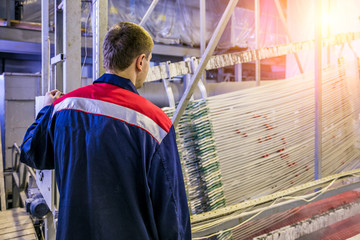 Worker pickling aluminium parts in tanks with etching acid to remove oxide cover 