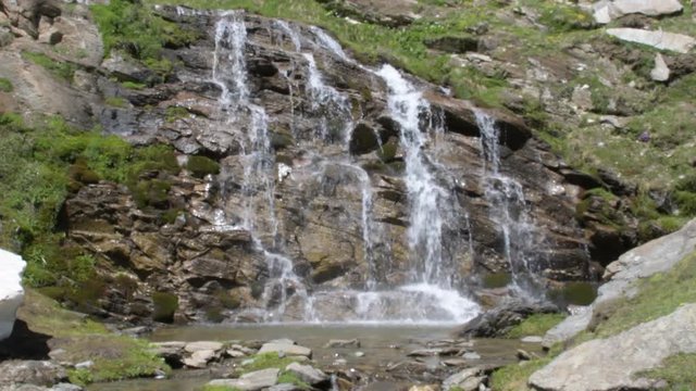 L'acqua scende sulla bella parete di roccia , formando una piccola cascata