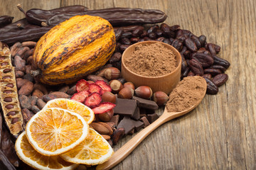 cacao pods, carob pods and dried fruits on wooden background