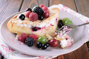 Piece of homemade cake like cheesecake or tart with cottage cheese filling and baked icing cream and fresh berries on top, top view
