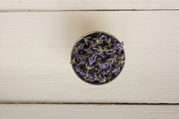 Obraz na płótnie Canvas Closeup photo on top of a wooden background with a small bowl with fragrant lavender.