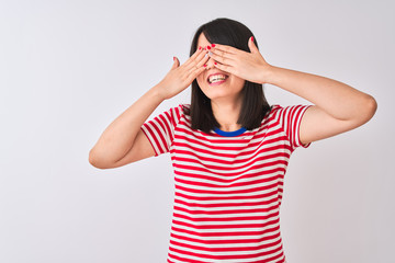 Young beautiful chinese woman wearing red striped t-shirt over isolated white background covering eyes with hands smiling cheerful and funny. Blind concept.