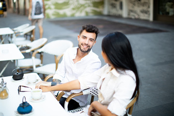 young mix couple asian and caucasian breakfast in the street happy