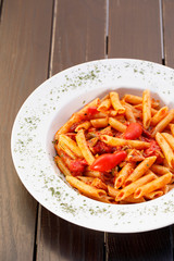 Plate of pasta with tomato , Italian healthy food , wood background.