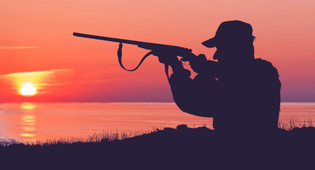 Hunting period, autumn season open. A hunter with a gun in his hands in hunting clothes in the...