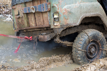 Fototapeta na wymiar Rally on Russian SUVs in the mud in winter, Trapped all-terrain vehicle pulled out of the river 