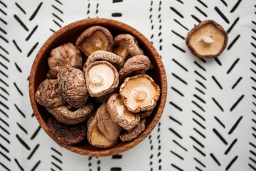 Chinese dried mushrooms Shiitake in a wooden bowl on a table. The concept of medicinal superfoods for health. Top view, flat lay.