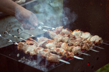 Skewers are cooked on charcoal on the grill. Pork meat on skewers.