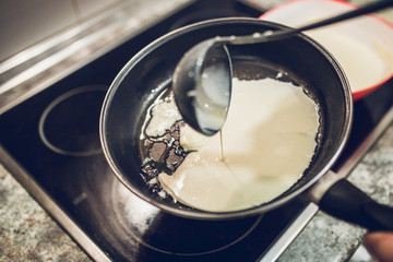Thin layer dough into the pan - home cooking thin sweet pancakes with filling