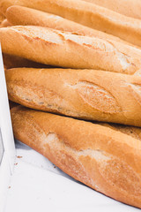 Close-up lots of fresh crispy baguettes on the counter - traditional Mediterranean market - selected top-quality organic products