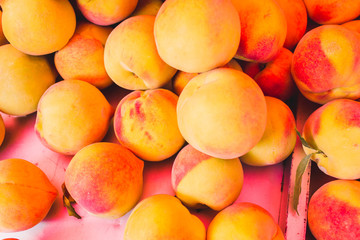 Closeup of many juicy ripe peaches on the counter - traditional Mediterranean market - selected top-quality natural products