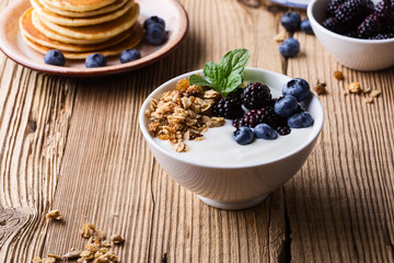 Morning meal, homemade granola with yogurt, fresh summer berries, fruits