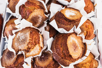 A lot of cupcakes in paper packaging close-up in a confectionery and bakery shop - selected top-quality natural products