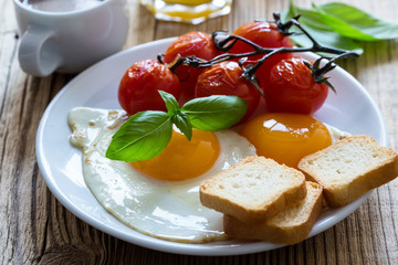  Fried eggs with cherry tomatoes, fresh summer fruits, berries, coffee and juice