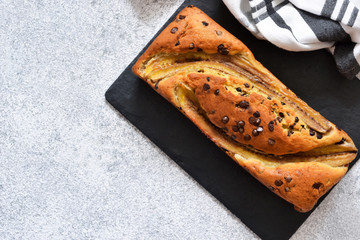 Banana cake with chocolate drops on the kitchen table. Classic dessert.