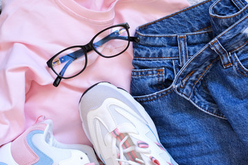 Fashion & Style. Sweatshirt, jeans and sneakers top view.