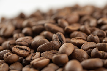 Roasted coffee beans on white background, macro