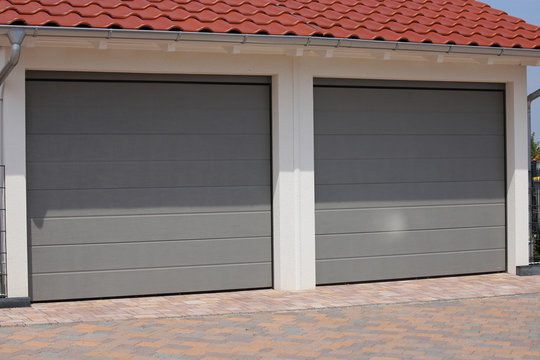 Zwei moderne neue Garagentore (Sektionaltore) in einem Wohngebiet