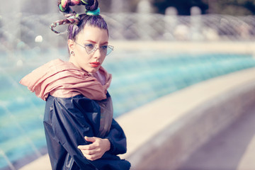 Outdoor close up portrait of a young lady with crazy look. Fashionable girl posing on street with...