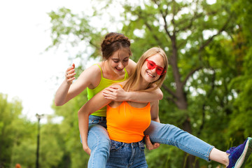 Two girlfriends walking on summer park, outdoors