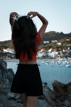 Modelo femenina toc&aacute;ndose el pelo en la costa mediterr&aacute;nea 