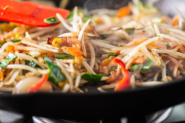 Process of cooking of sweet and crunchy stir fry with beansprouts in the wok, Macro image