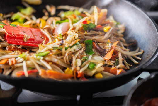 Process of cooking of sweet and crunchy stir fry with beansprouts in the wok, Macro image